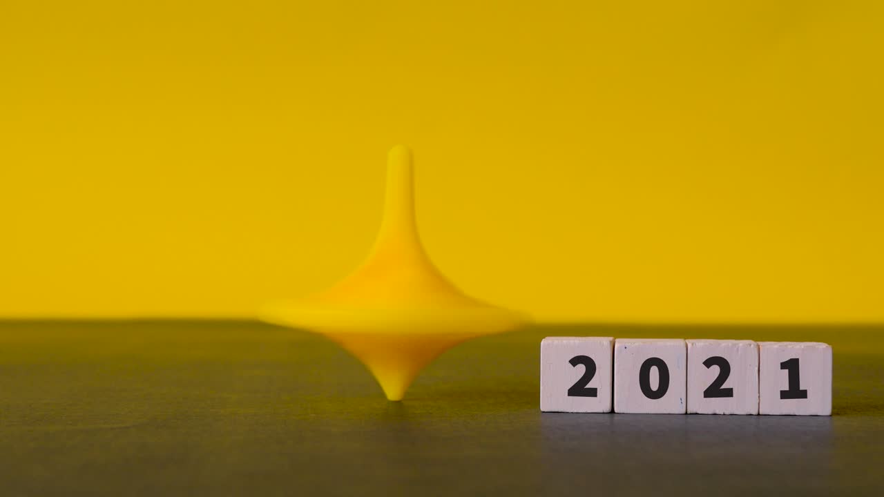 el trompo de hanukkah se tambalea frenéticamente y se asienta perfectamente junto a bloques de madera con los números 2021 en ellos