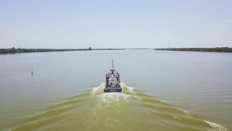 barco desde detrás de la estela en el agua del río jacui, brasil