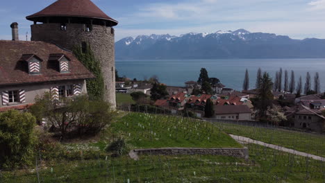 vuelo aéreo lento junto a una bodega de piedra y sobre viñedos en el campo de lutry, suiza en un día soleado