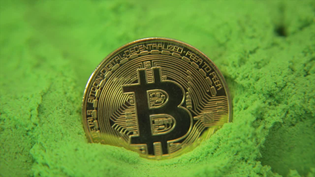 moneda de oro bitcoin en un mar de verde con destellos de luz y reflejos