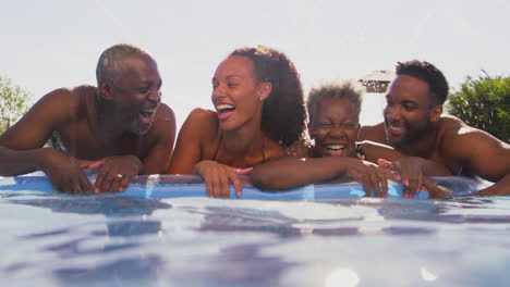 underwater shot of multi-generation family with adult offspring on summer holiday in swimming pool