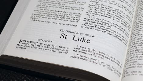 close up shot of bible page turning to the book of luke