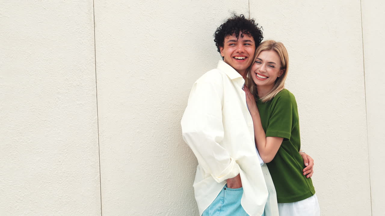 壁に寄りかかってポーズをとっている幸せなカップル
