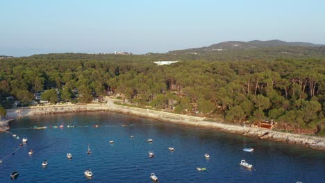 Toma-Aérea-De-Una-Bahía-Llena-De-Botes-Anclados-En-Mali-Losinj,-Croacia-En-Un-Día-Brillante