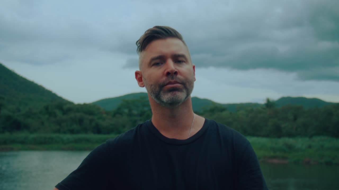 Man playing guitar by a river