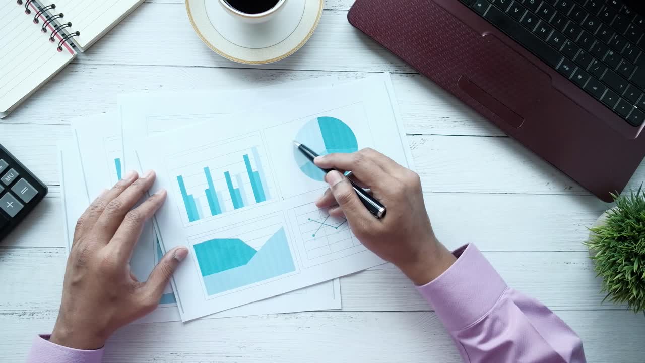 Person analyserer forretningsdiagrammer og grafer