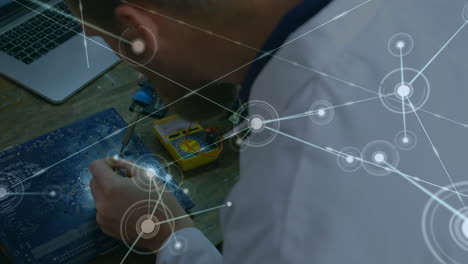 Animation of network of connections over caucasian man repairing computer hardware