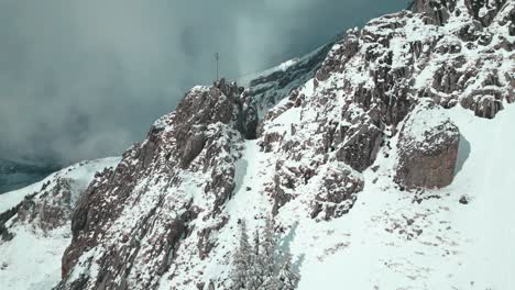 drone ziplining and strafing above the jagged, snowy slopes of a winter destination in engelberg brunni bahnen in switzerland