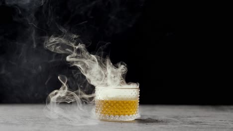 smoke rolling off of a cocktail with a black background