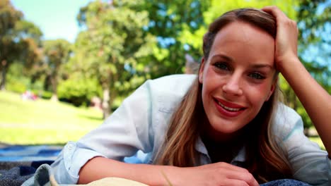 bonita rubia sonriendo a la cámara en un parque
