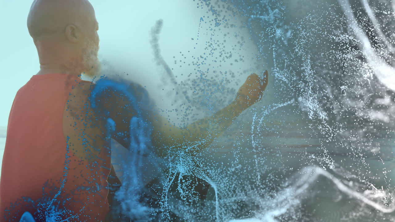 mature adult man raising arm in tech studio, interacting with blue white digital particle streams