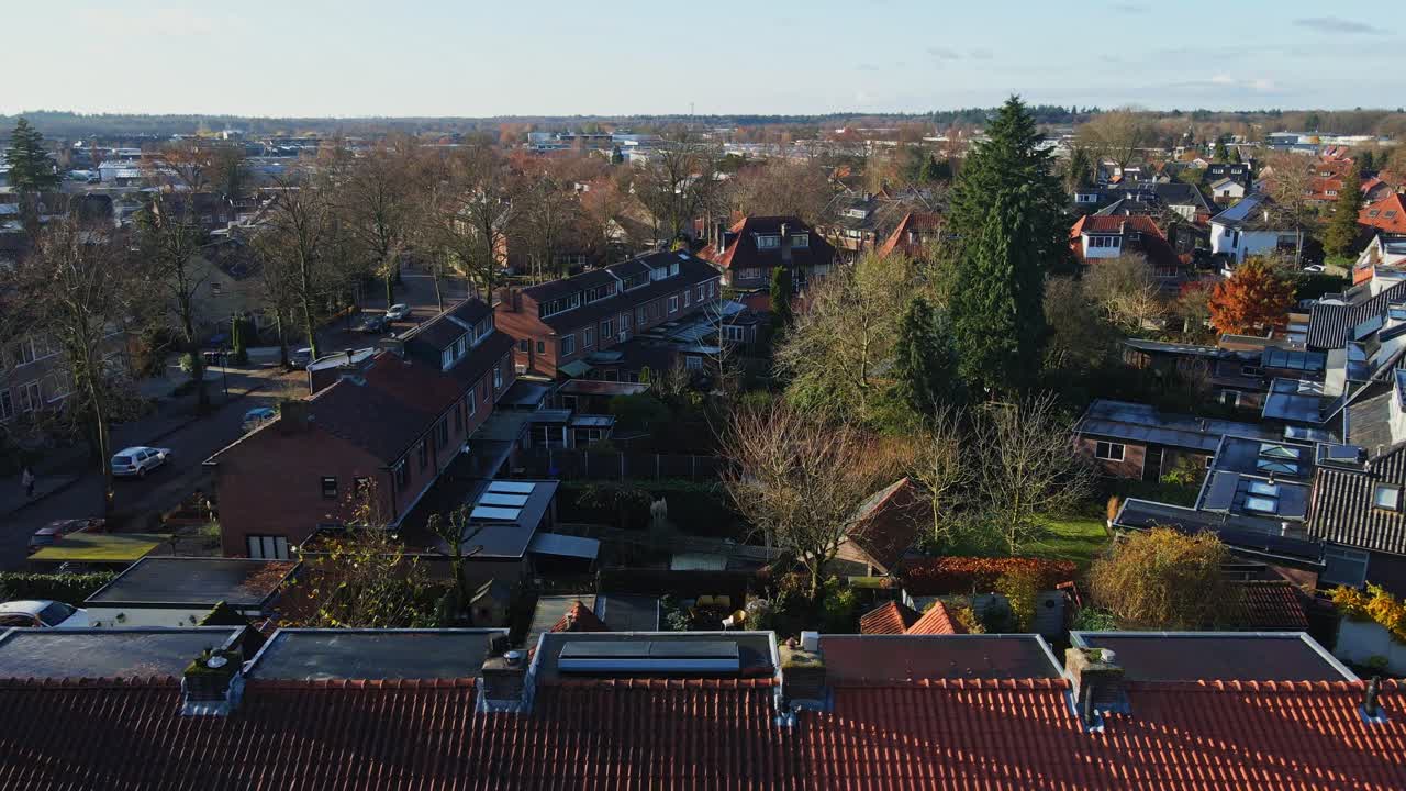 드론이 지붕 위를 날아다니며 평화로운 교외 동네의 작은 집 블록을 드러니다.