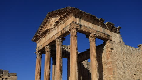 Luz-Dorada-Del-Sol-Bañando-Las-Ruinas-Romanas-De-Dougga,-Fondo-De-Cielo-Azul-Claro