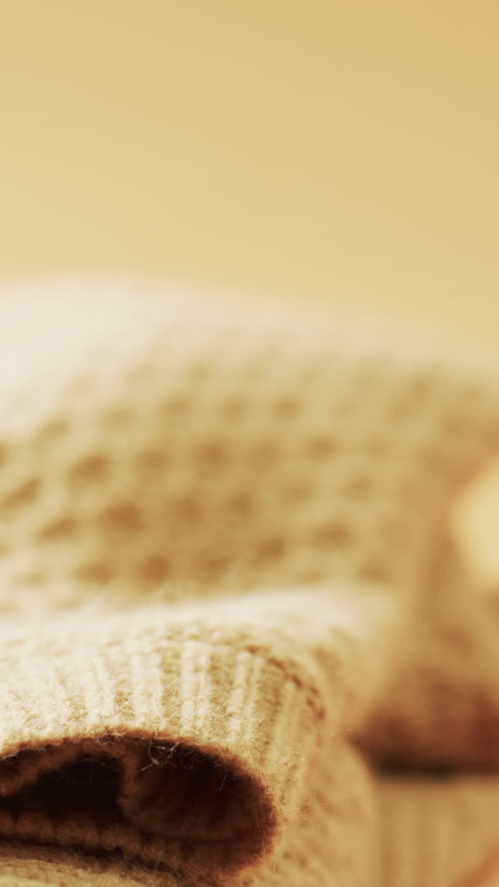 Micro vertical video of close up of yellow wooly crochet fabric with copy space on yellow background