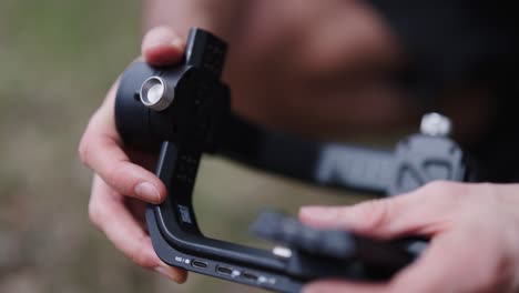 persona ajusta la posición del eje del estabilizador de gimbal para equilibrar el equipo de la cámara