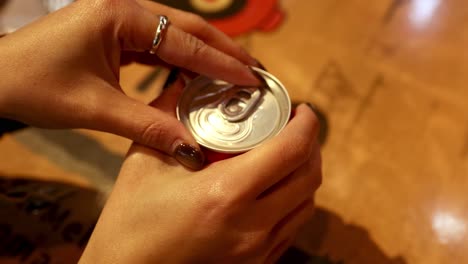 hands opening a cola can