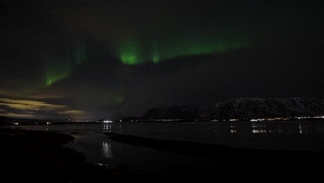 time lapse shot of northern lights at night sky on lake in iceland - static wide shot