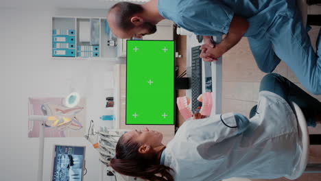 Vertikales-Video:-Zahnarzt-Und-Assistent-Schauen-Auf-Den-Grünen-Bildschirm-Am-Computer