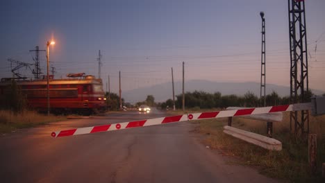 night train passing road with closed barriers