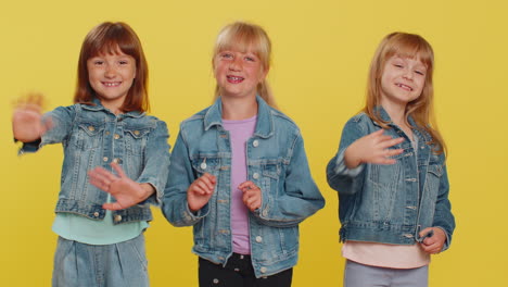 three girls siblings friends smiling waving hands gesturing hello or goodbye welcoming to join
