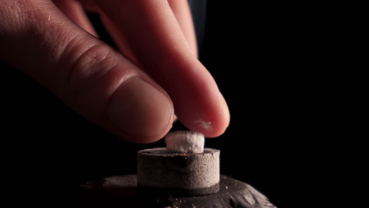 incienso sobre carbón autoencendido, fondo negro