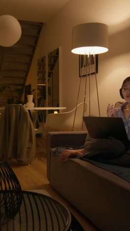 woman having a video call in a modern living room at night