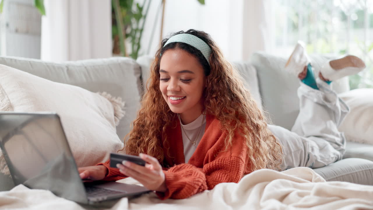 Giovane donna che fa acquisti online sul divano.