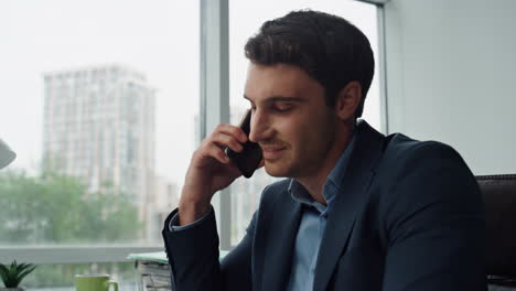 Hombre-De-Negocios-Confiado-Hablando-Por-Teléfono-Móvil-De-Cerca.-Gerente-Sonriente-Discutiendo