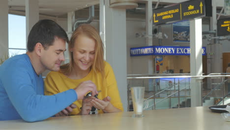 pareja adulta feliz con teléfonos inteligentes