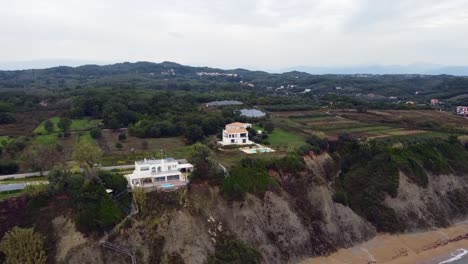 buttery soft aerial drone flight fly forwards drone shot from offshore tu luxury villas on a cliff