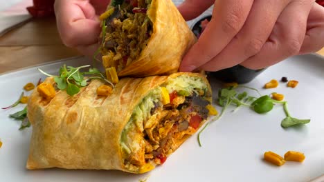 picking up a delicious chicken wrap with vegetables, cheese and salad in marbella spain, brunch during summer at a restaurant, 4k shot