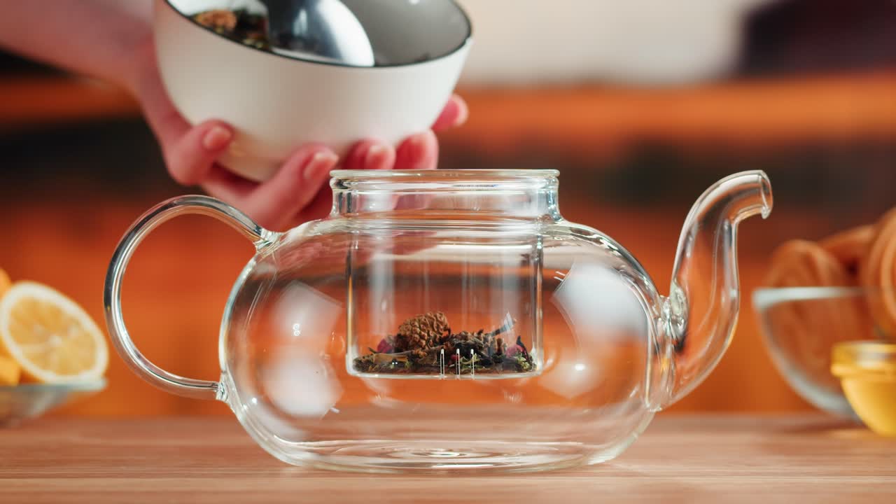 Preparing loose leaf tea in a clear glass teapot