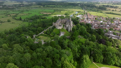 green trees in the park with arundel castle and town in west sussex, england, uk. - aerial shot