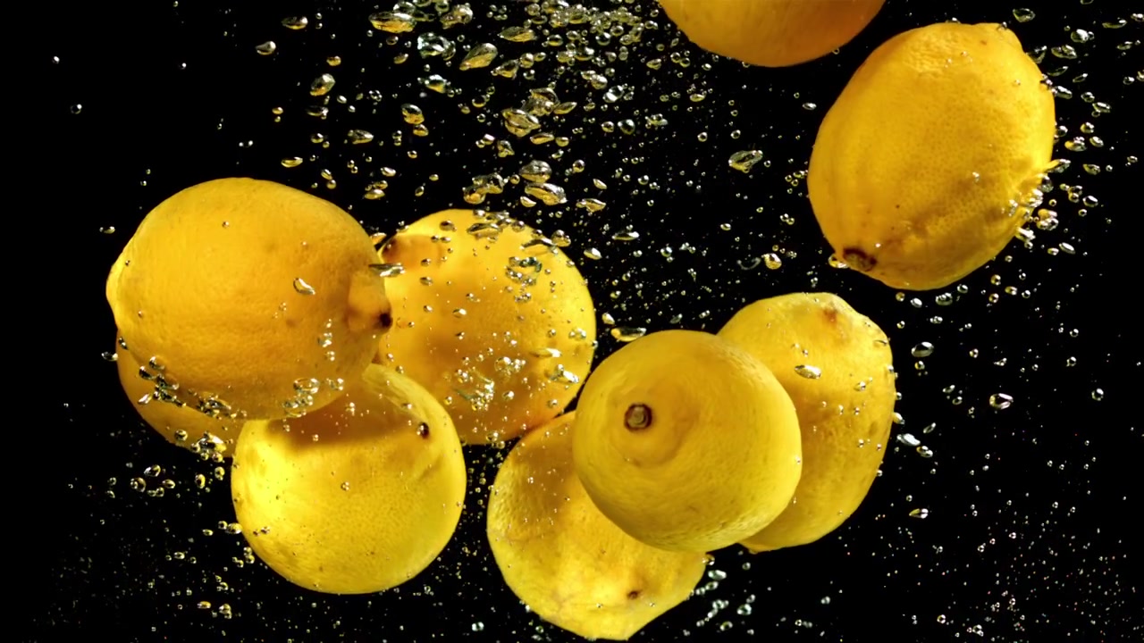 Vibrant Yellow Lemons Submerged in Clear Water with Bubbles