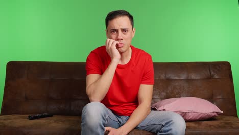 Sad man crying watching a movie on green screen background