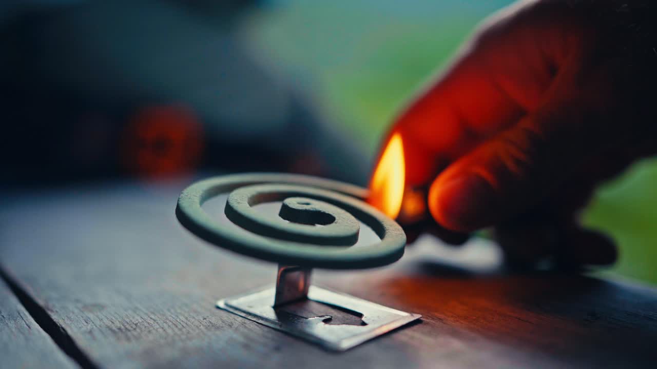 A Hand Lights a Mosquito Coil at Camp During a Hiking Trip in SørTverrfjord, Loppa, Finnmark, Norway - Close Up
