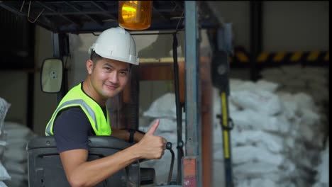 a worker asia drives forklift in the factory.