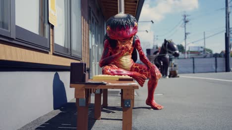 Japanese-River-Monster,-the-Kappa,-sitting-on-bench-playing-Go-in-Fukusaki