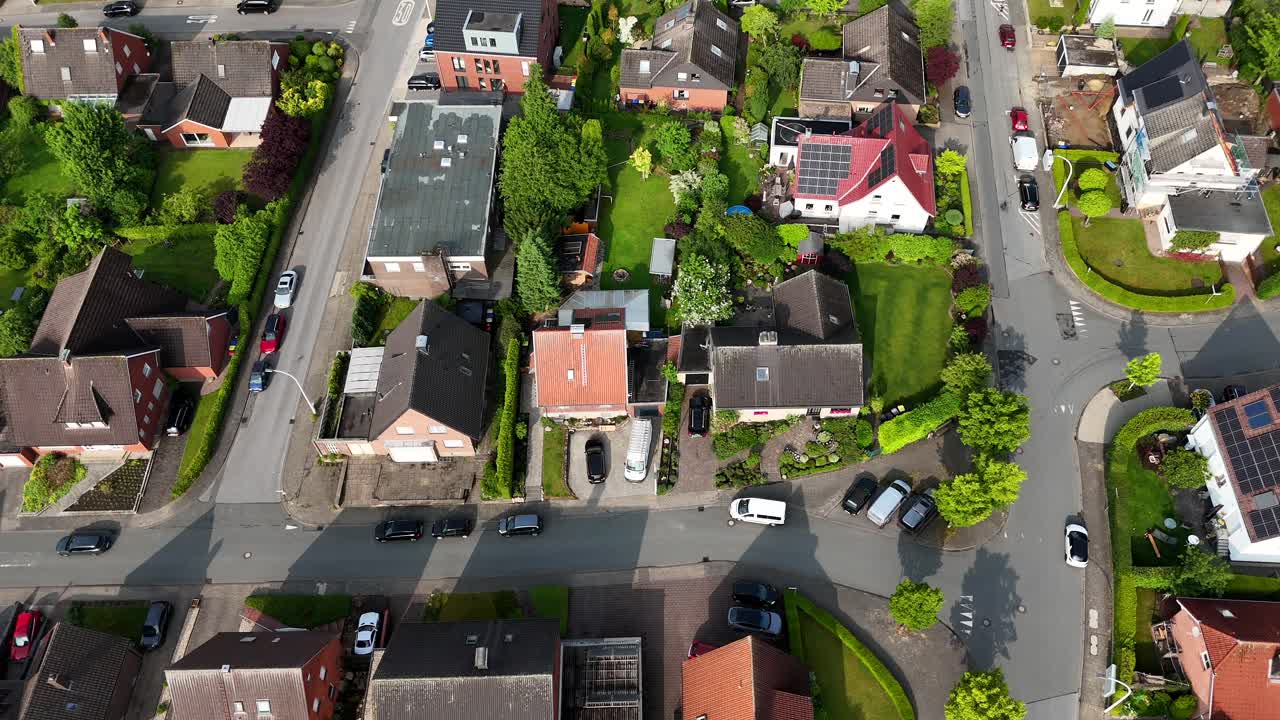American settlement with single family house and solar panel on roof. Sunny day in summer. Cars on street. Aerial top down flyover. Green garden in small village of United States.