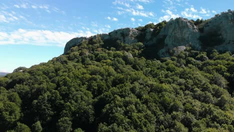 Aerial-footage-of-blue-sky,-white-clouds,-birds-and-cliffs-over-a-forest,-Kotel,-Bulgaria---October-15th,-2018