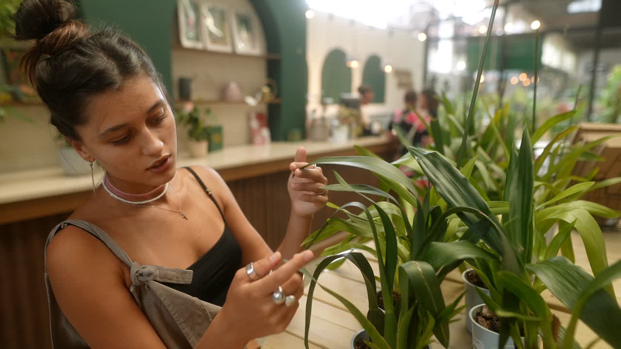 Woman examining plants at an indoor market
