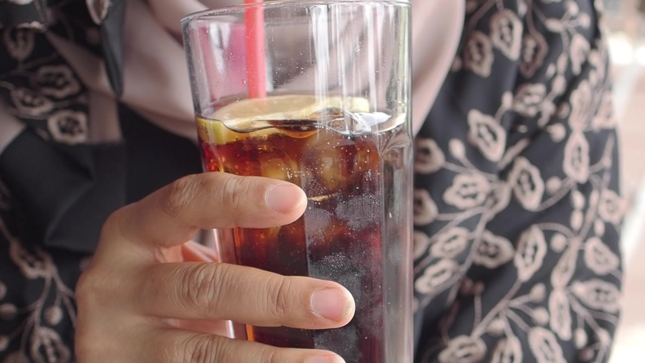 Pessoa Segurando um Copo de Cola Gelada com Limão