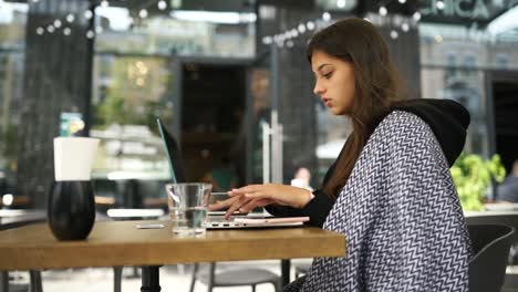 una mujer joven trabajando en un café.