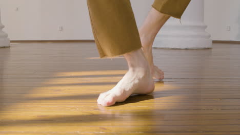 primer plano de un hombre irreconocible que realiza una danza contemporánea en el estudio