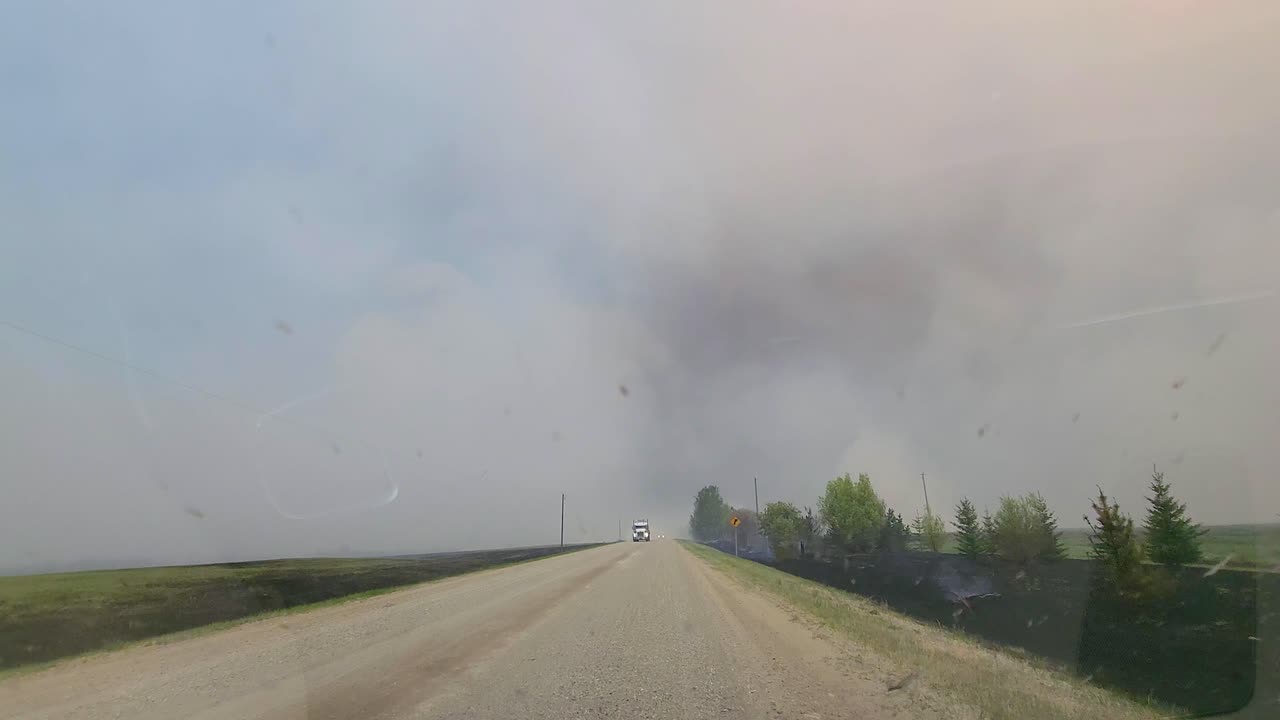 pov de coche conduciendo en la carretera con una vista de humo de incendios forestales