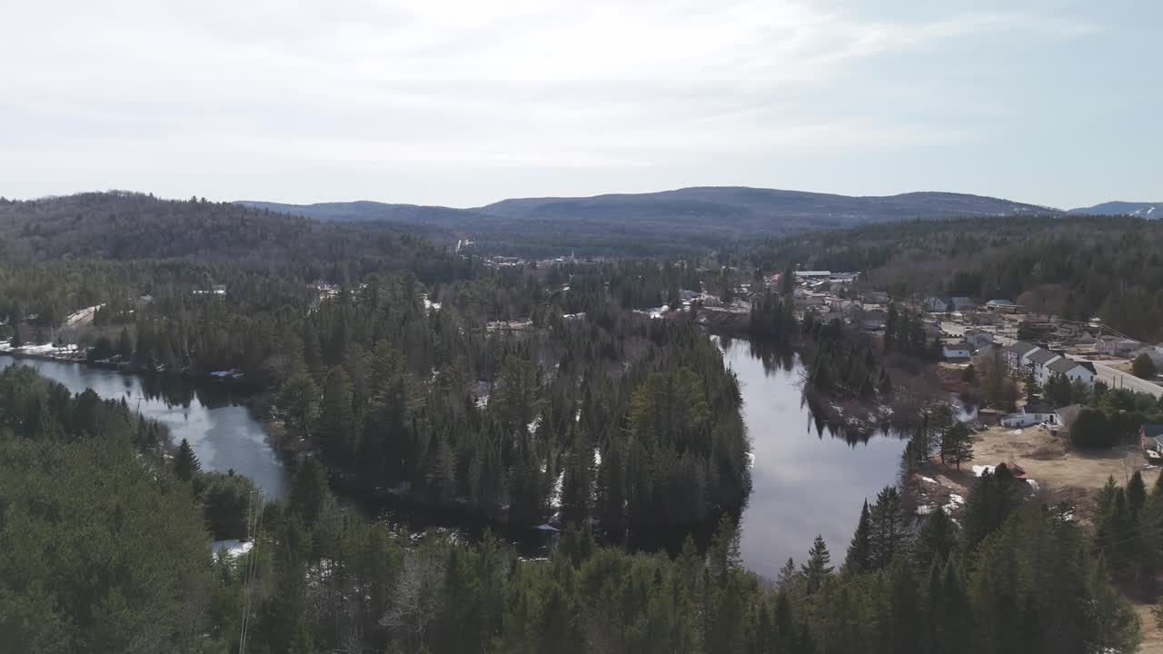 un dron vuela sobre el municipio de saint-côme en la región de lanaudière de quebec revelando un paisaje forestal pintoresco con un lago y un río