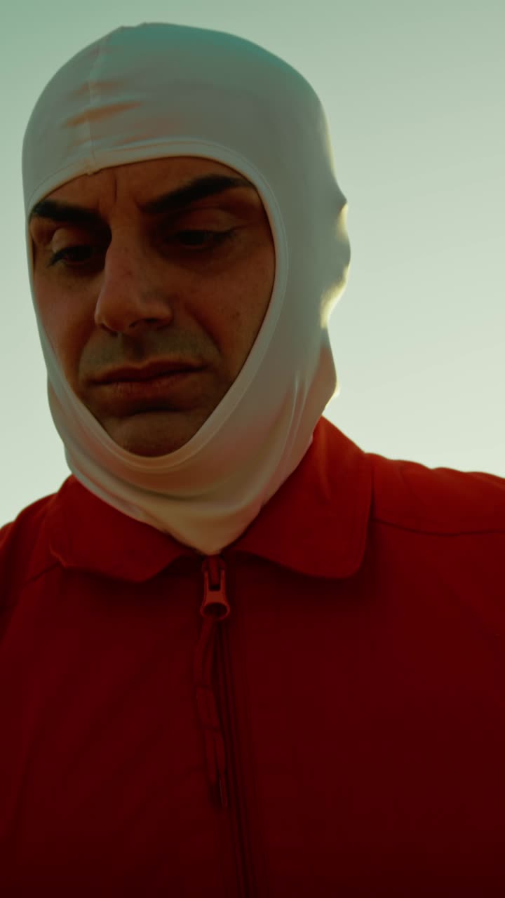 오렌지색 의상을 입은 우주 비행사가 적대적인 행성에서 독성 꽃의 새를 맡습니다.