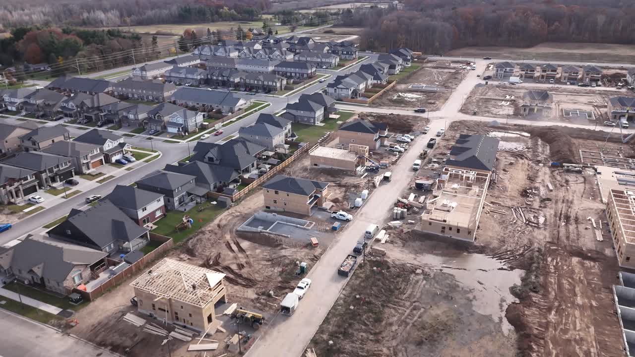 sobrevuelo de drones de suburbios terminados junto a la construcción de nuevas casas en varios estados de finalización