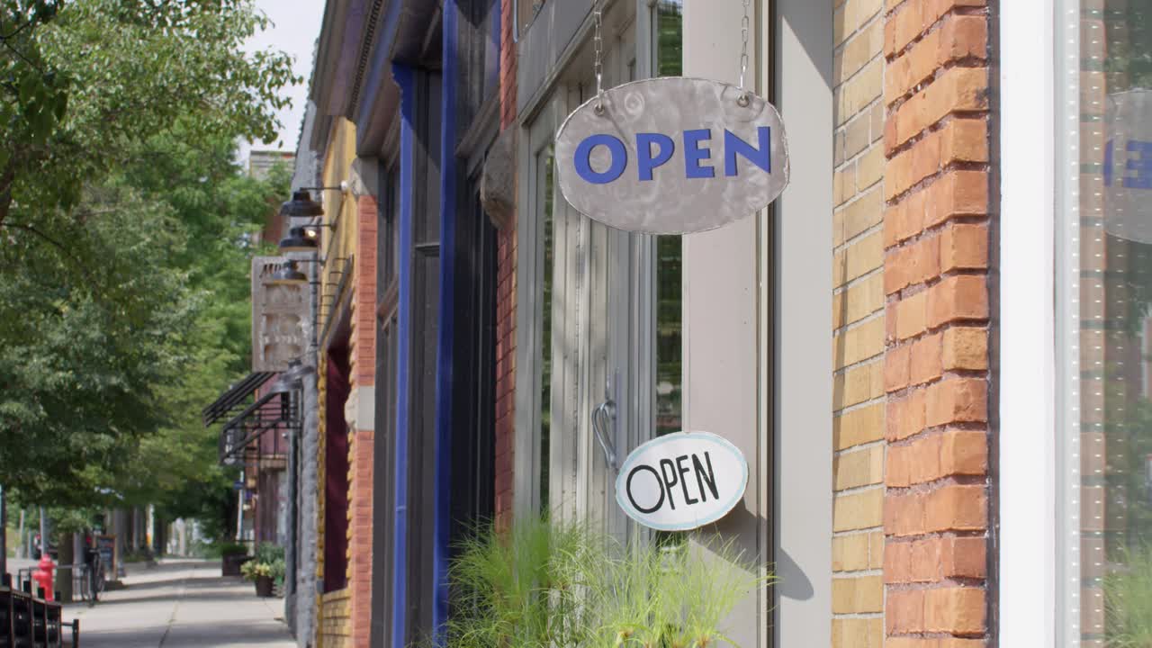 Insegne "Aperto" nel quartiere storico di Lansing, Michigan, con una stabile ripresa video introduttiva.