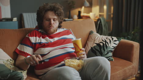 man watching tv and eating